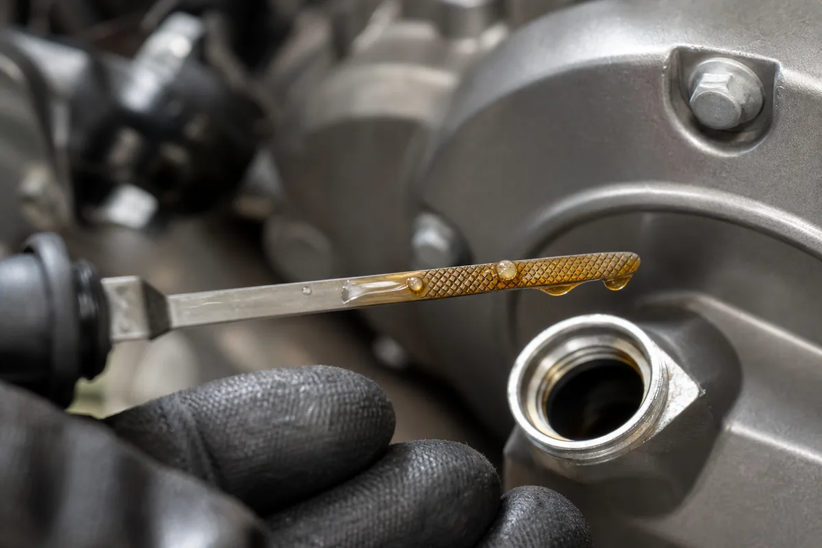 Contrôle du niveau d’huile moteur à la jauge sur une moto
